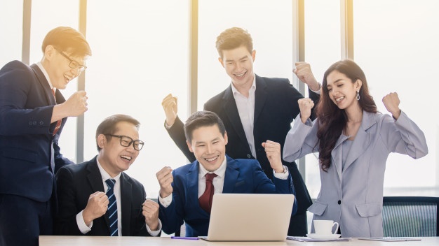 Business team cheering at a laptop. Licensed moneylender KL Selangor.